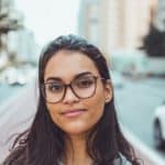 Frau mit Brille lächelt in Kamera