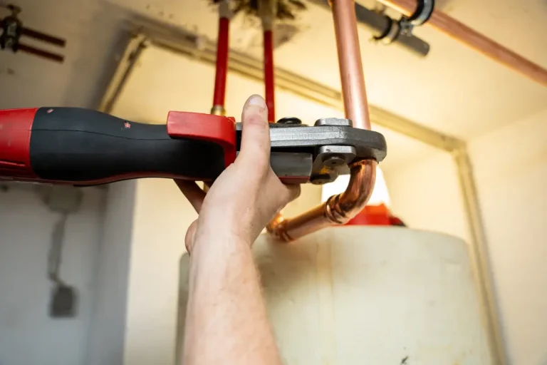 Handwerker bei Montage von Heizungsrohren